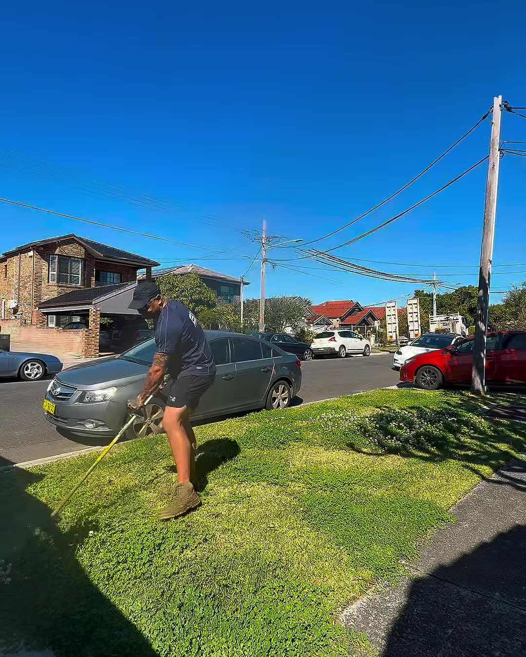 Shaggy lawn with grass growing over the footpath in Kingsford